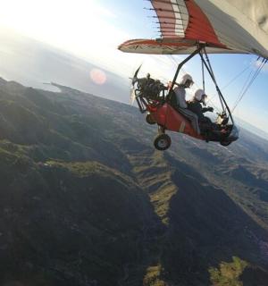 grupp inimesi, kes lendavad helikopteriga mäe kohal