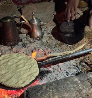 a person cooking a pie on top of a fire