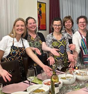 a group of women standing around a table
