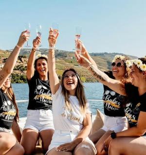 a group of women sitting on a boat with their hands in the air