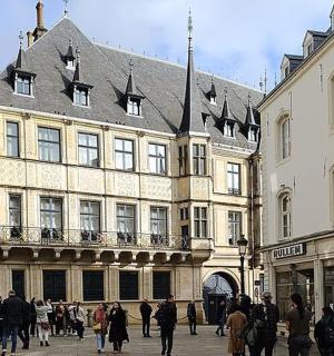 grupa ludzi idąca przed budynkiem