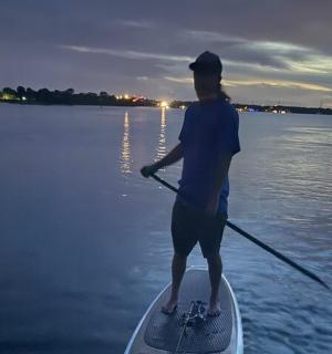 一名男子站在水上的桨板上