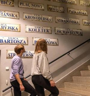 两个人走上楼梯，墙上挂着标语