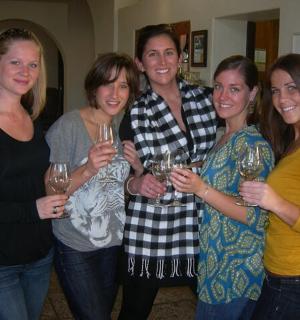 a group of women standing together holding wine glasses