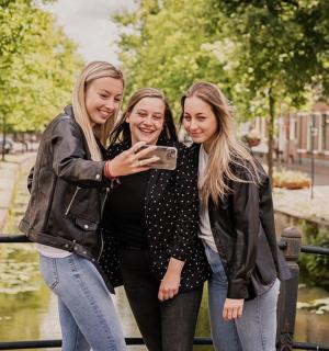 三个女孩用手机拍照