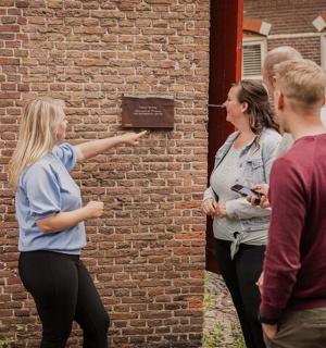 一群人站在一堵砖墙周围