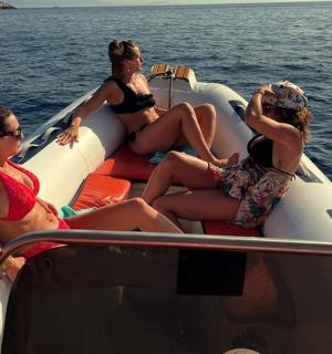 a group of women sitting on a boat in the water