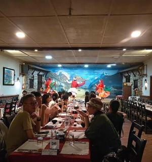 a group of people sitting at tables in a restaurant