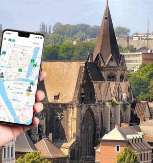 osoba držící mobilní telefon před kostelem