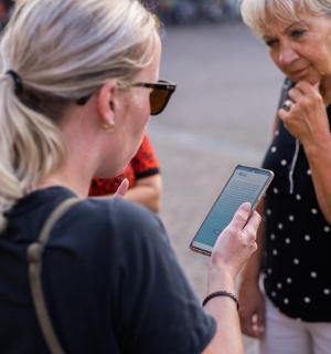 dwie kobiety patrzą na telefon komórkowy