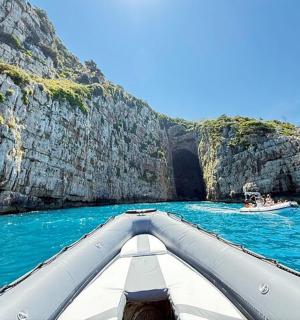 a boat in the water in front of a cave
