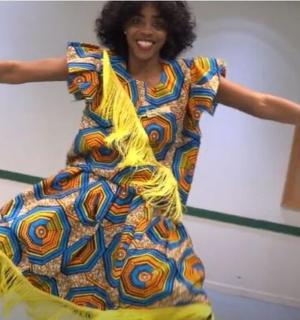 a woman in a colorful dress is dancing