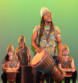 a group of people playing drums in front of a wall