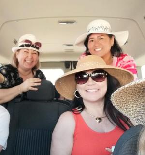 a group of women wearing hats in a car