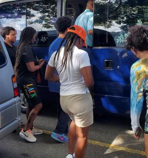 a group of people standing outside of a van