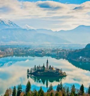 an island in the middle of a lake with mountains