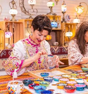 一群人坐在一张桌子旁，桌上摆着陶器