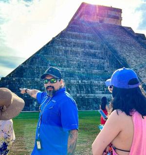 a group of people standing in front of a pyramid