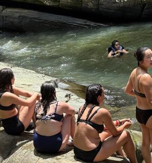 eine Gruppe von Menschen sitzt auf Felsen im Wasser