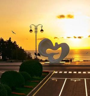 停车场上空的日落和心形雕塑