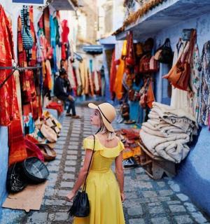 žena ve žlutých šatech kráčející po ulici