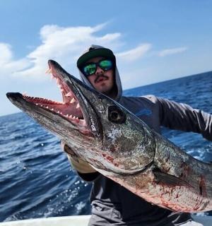 a man holding a large fish in the ocean