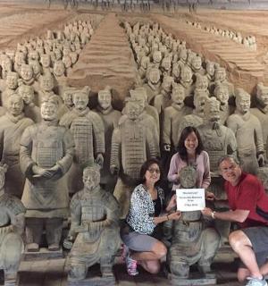 a group of people posing in front of a large statue