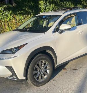a white lexus explorer is parked on a street