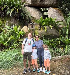 a family posing for a picture in front of a garden