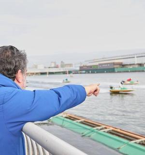 a man pointing at boats in the water