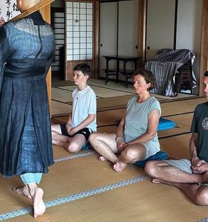 一群人坐在地板上,旁边是一位女士