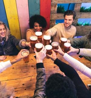 一群人围坐在桌旁喝啤酒