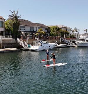 dva lidé stojí na paddleboardech ve vodě