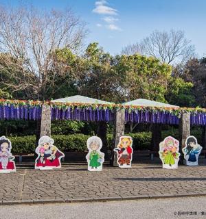 a group of figurines sitting in front of a gate