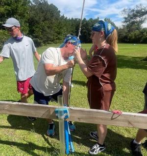 a group of people standing around a wooden fence