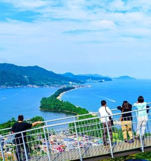 a group of people standing on a ledge overlooking a body of water