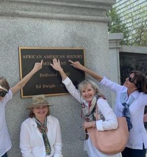 a group of women standing in front of a sign
