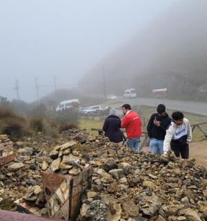 um grupo de pessoas em pé no topo de uma pilha de pedras