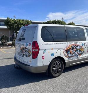 bílá dodávka parkuje na parkovišti