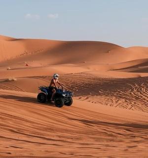 eine Person, die in der Wüste ein Quad fährt