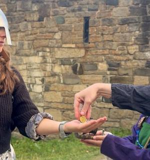 一名戴着头盔的女子正在递给一名男子一些东西