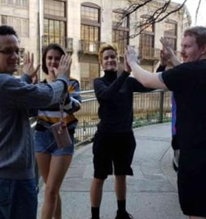 a group of people standing on a bridge with their hands up