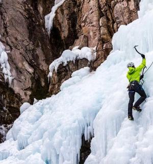 a man is rappelling off of a ice wall
