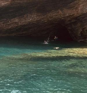 a group of people in a cave in the water