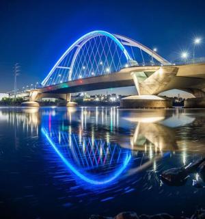 夜晚,水面上闪烁着蓝色灯光的桥梁