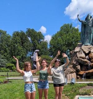 三个女孩站在雕像前