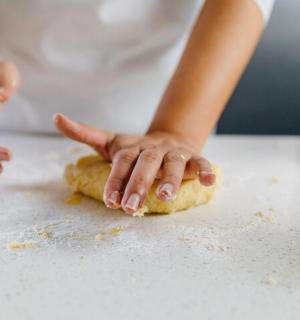 a woman is making a dough on a counter