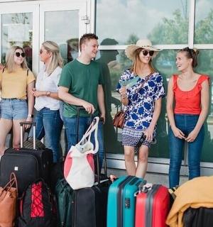 a group of people standing next to their luggage