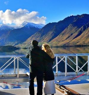 一男一女站在桥上俯瞰湖泊