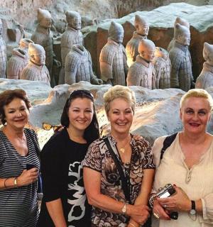 a group of women standing in front of a statue